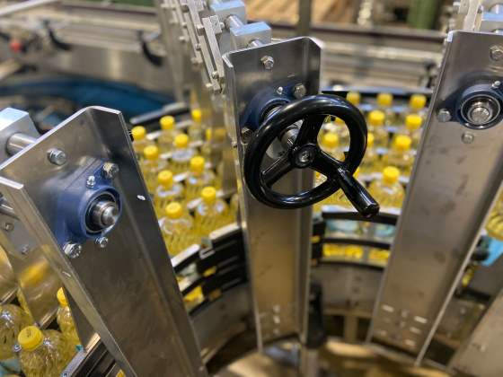 Sistema de guía ajustable para canalizar las botellas en tramos curvos