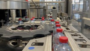 Ligne de mise en bouteille PET 12 000 bph pour eau naturelle et pétillante, avec souffleuse Krones, remplisseuse Simonazzi et étiqueteuse Contiroll.